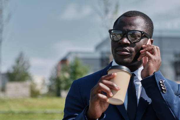 istock African businessman outoor drinking coffee, using smart phone 1257184868