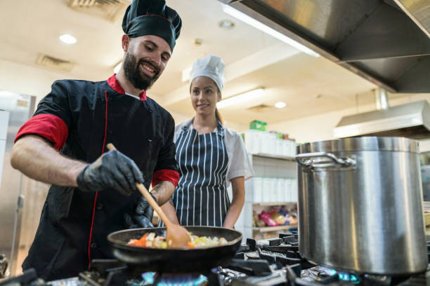 cocineros trabajando en la cocina del restaurante - hygiene food chef trainee fotografías e imágenes de stock