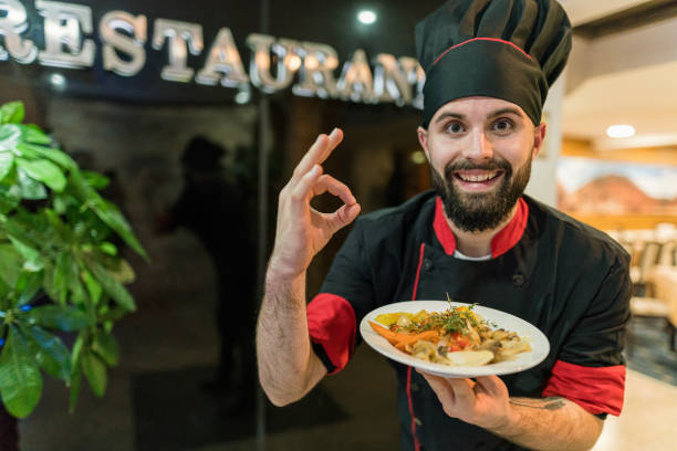 istock Young chef presenting food at the restaurant 1257185950