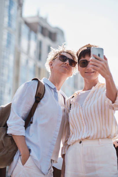 istock Two women using smart phone outdoor 1257186162