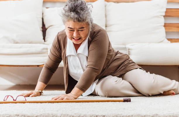 femme âgée asiatique tombant couchée sur le plancher à la maison seule. douleur de femme âgée et blessé par la maladie d’ostéoporose ou la crise cardiaque. assurance-vie pour adultes anciens avec le concept de soins et de traitement de foyer - single drop photos et images de collection