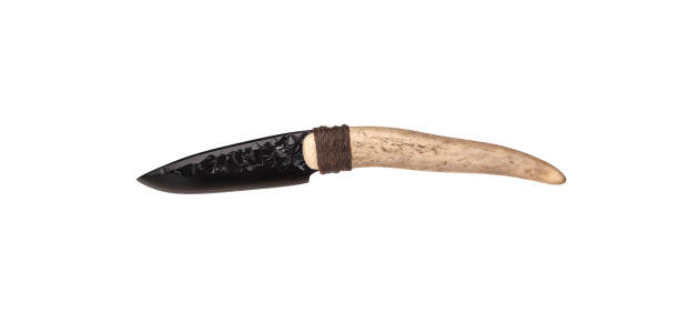 Obsidian knife with bone handle isolate on a white background. Prehistoric weapon made of volcanic glass.