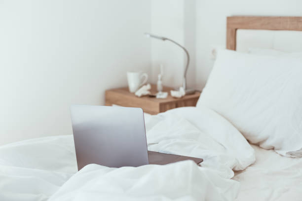 istock Working home isolation concept. Laptop in bed 1257190280
