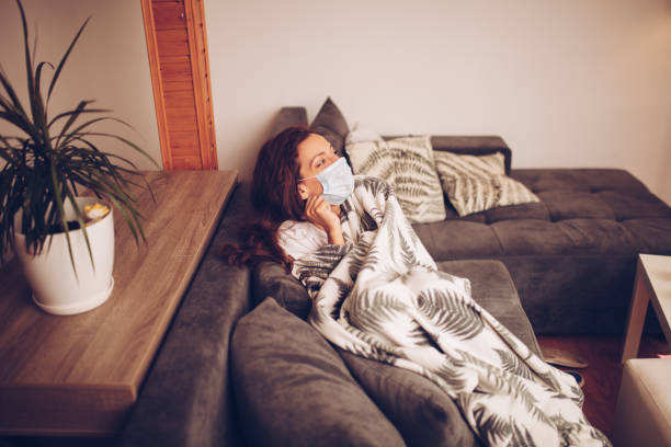 istock Girl lying in bed with cat wearing protective mask 1257190688