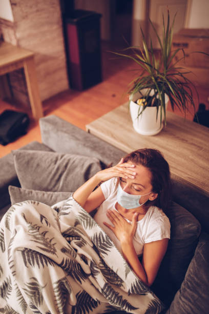 istock Girl lying in bed with cat wearing protective mask 1257192698