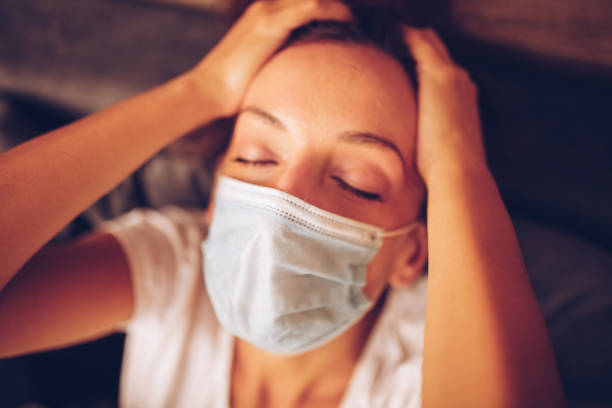 istock Girl lying in bed with cat wearing protective mask 1257193546