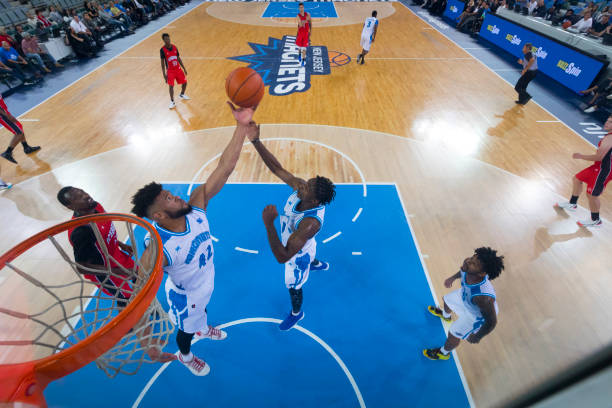 High Angle view of basketball players attempting slam dunk during match.