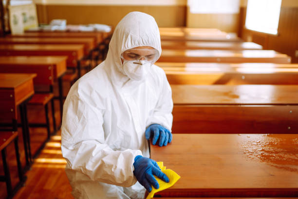 istock Man in a protective suit washes school desk. 1257199314