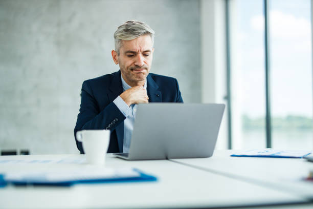 istock Mid adult businessman reading a problematic e-mail on laptop in the office. 1257201894