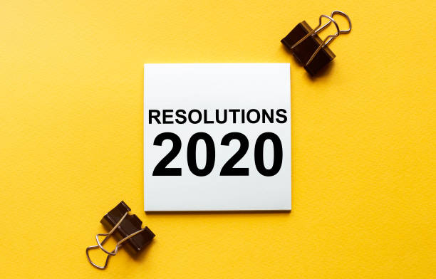 istock white paper with text Resolutions 2020 on a yellow background with stationery 1257205317