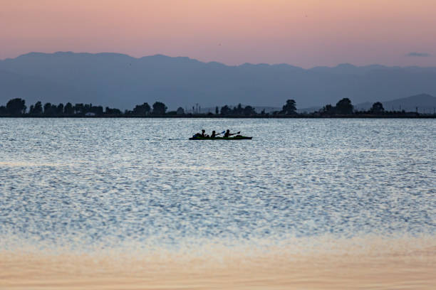 Landscape of a lagoon beach in the mediterranean sea while three people are in a kayak