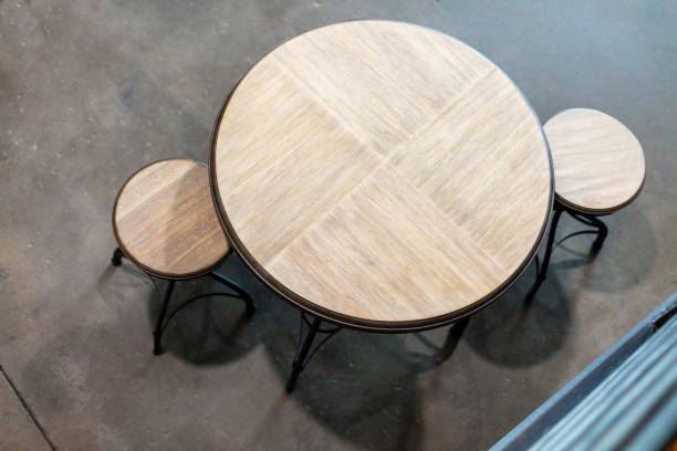 istock Empty Round Wooden Surface Bistro Table Top and Stools on cement Flooring Shot from Above 1257206993