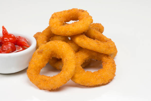 istock Onion rings in  white background and pepper 1257207317