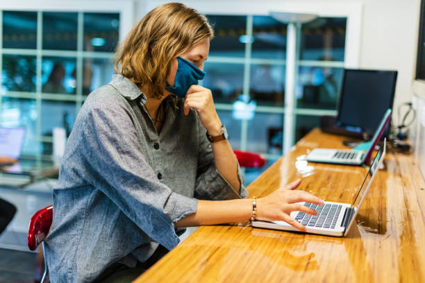 istock College Student Wearing Face Mask Working on laptop technology in Computer Lab Setting 1257207327