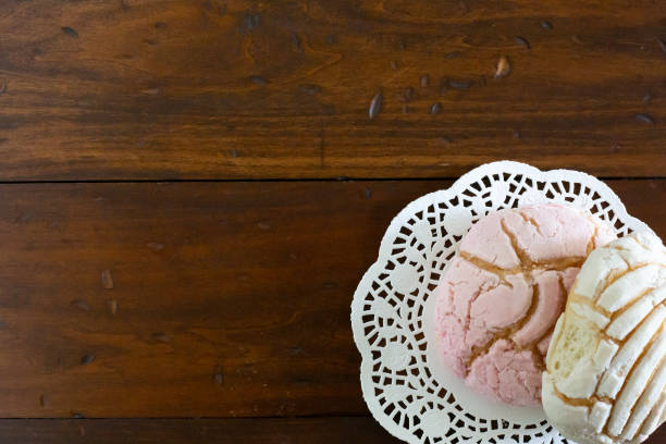 istock Pink and white Mexican sweet bread conchas on a doily 1257208209