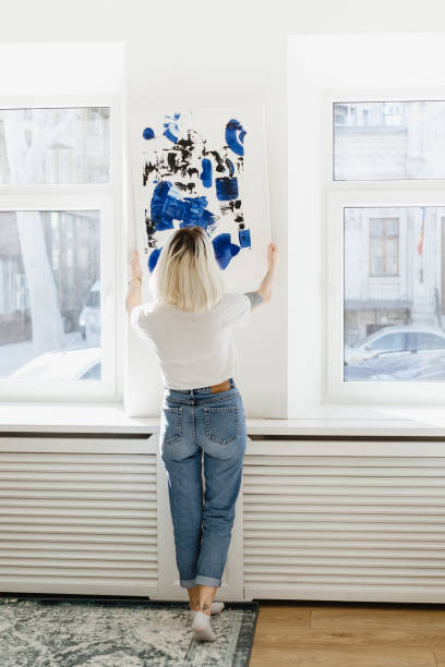 istock Young woman placing abstract paint on the wall 1257208945
