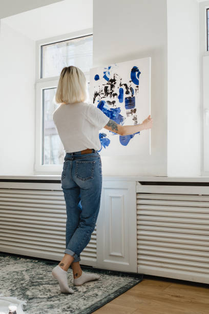 istock Young woman placing abstract paint on the wall 1257208957