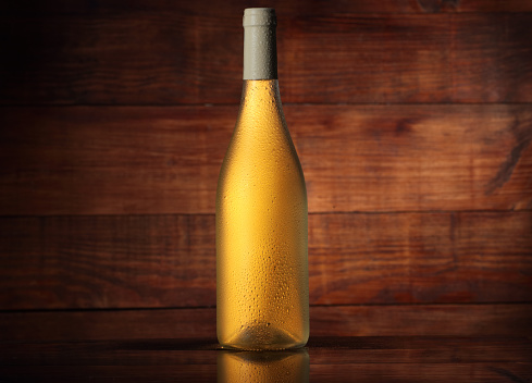 full wine bottle without label on wooden background