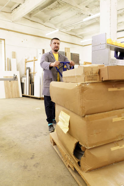 istock Man carry furniture cardboard boxes in their workshop 1257212242
