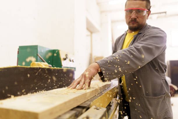 istock Male carpenter using saw for cutting wood at workshop 1257212257
