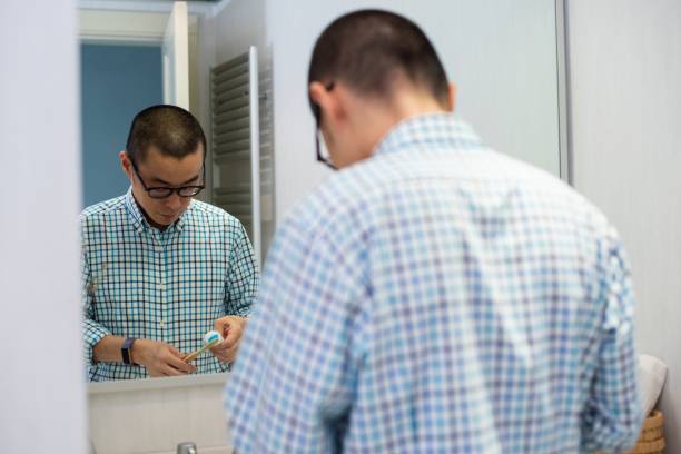 istock Mid adult man brushing his teeth 1257213050