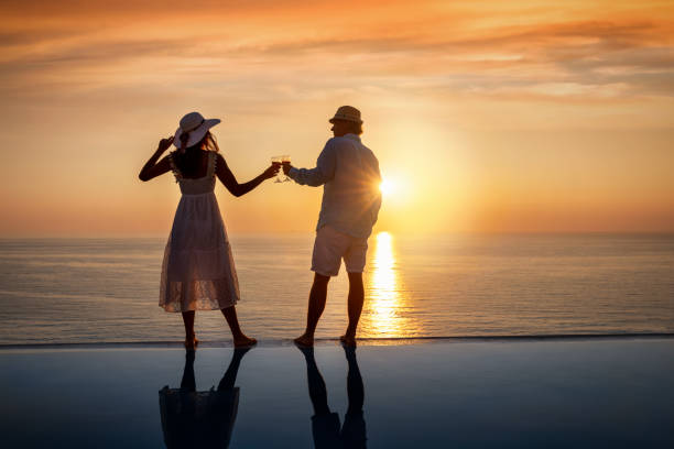 istock A happy couple with drinks in their hands by the pool on summer vacation time 1257213456