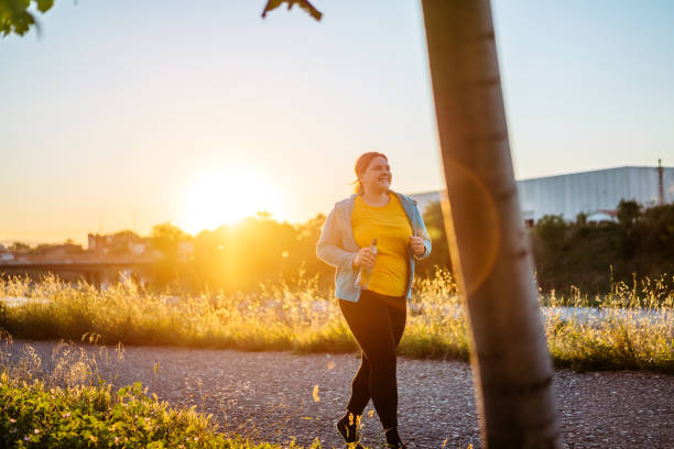 istock Young overweight woman running 1257217128