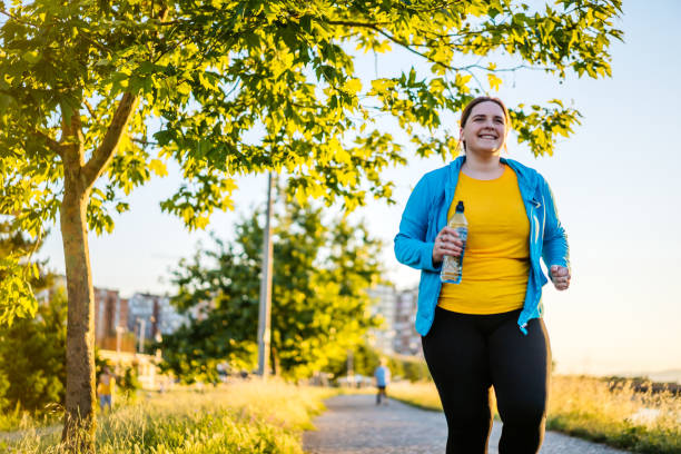 istock Young overweight woman running 1257218665
