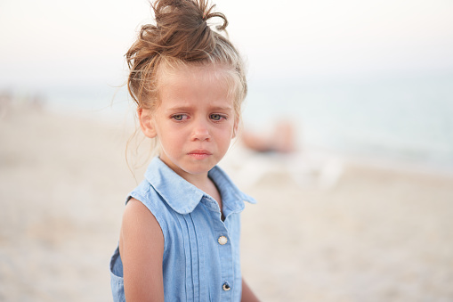 Little girl crying beach. Sad Summer Vacation. the child is lost Scared small adorable caucasian kid