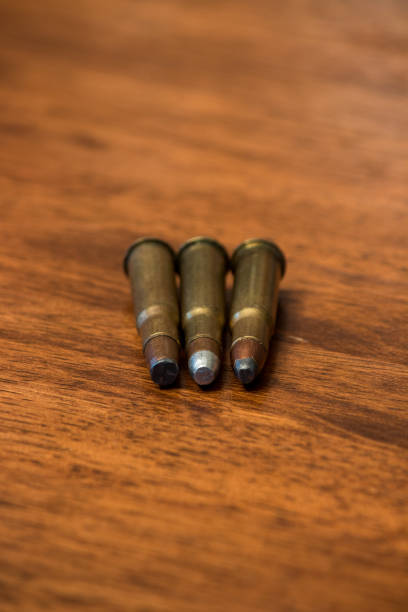 istock Three bullets laying on wooden background 1257221437