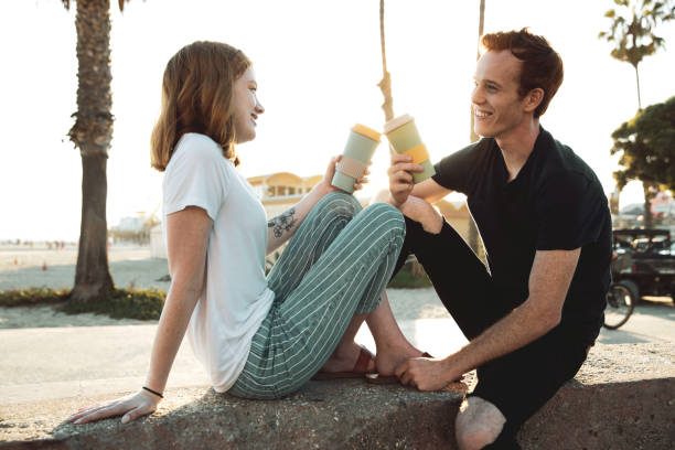 jeune couple romantique buvant le café sur la promenade de santa monica - santa monica beach city of los angeles california photos et images de collection