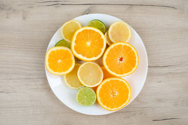 istock Plate with cut citrus on wooden background. Top view 1257225030
