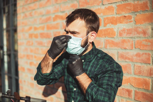 The guy puts a protective mask on his face stock photo
