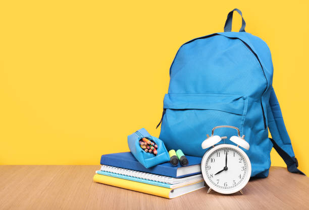istock Blue backpack and stationery on a yellow background, place for text. Learning concept 1257229021