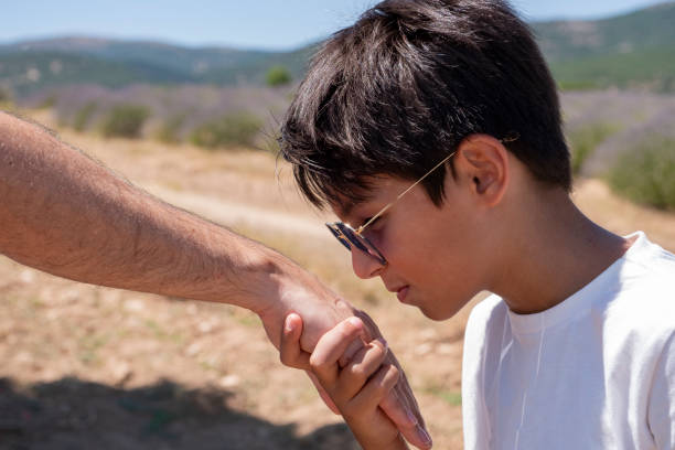 istock Kid kissing parent's hand in outdoor. 1257230543