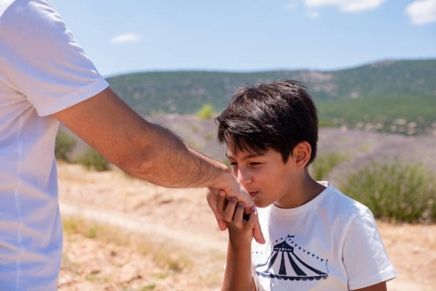 istock Kid kissing parent's hand in outdoor. 1257230558