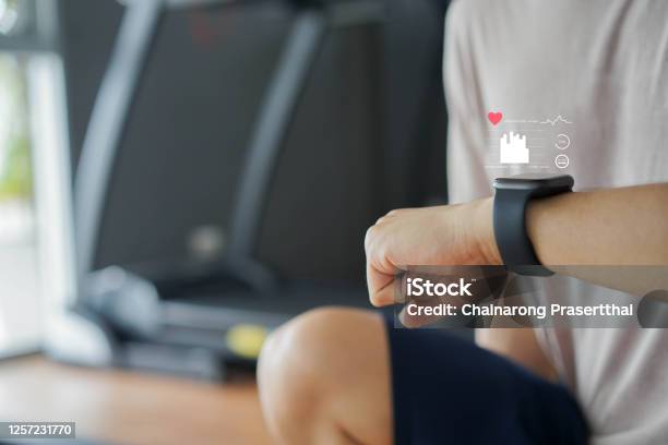 Close Up Young Man Using Smart Watch To Monitoring About Healthcare Tracker With Virtual Display To Measure Heart Rate And Calories While Workout And Rest For Technology And Futuristic Life Concept Stock Photo - Download Image Now