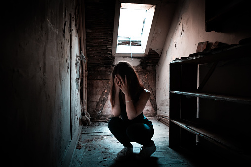 Depression Desperate Woman hiding her Face alone in House Attic