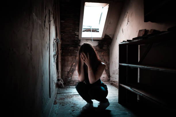 Depression Desperate Woman hiding her Face alone in House Attic Desperate young sad woman crouching on old house attic, crying with her hands hiding her face. Loneliness, Depression Young Woman Concept. sad girl crouching stock pictures, royalty-free photos & images