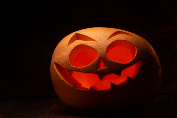 istock Halloween pumpkin with scary face. Jack-o-lantern in the dark 1257232515