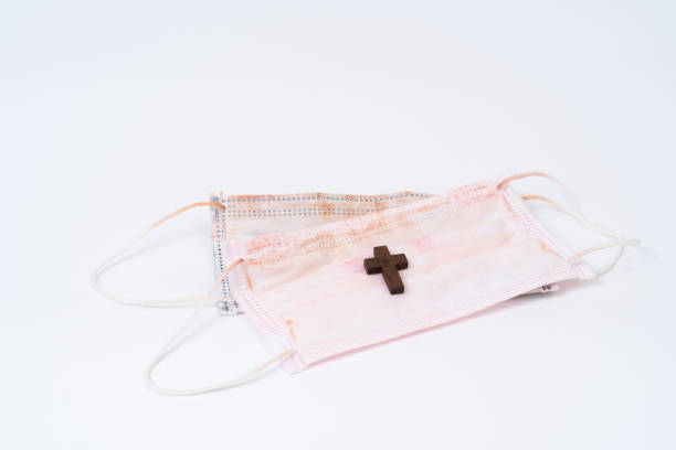 istock Used face mask and wood cross 1257233889