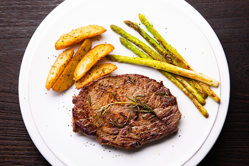 Grilled steak with baked potatoes and asparagus