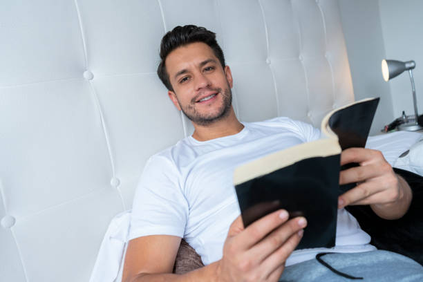 istock Latino ethnic man lying in bed reading a book during Covid-19 1257237781