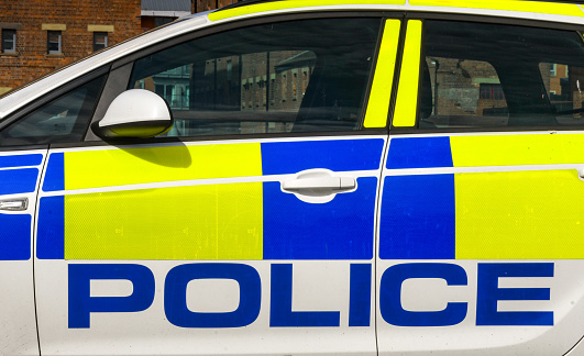 Gloucester, England - September 2019: Close up view of the side of a police patrol car parked in Gloucester city centre