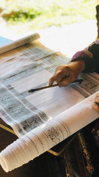 istock Hilltribe lady drawing patterns on cotton cloth 1257239126