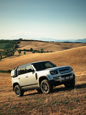 Torrita di Siena, Italy - July 12, 2020 : The New Land Rover Defender 2020 is parked on a wheat field