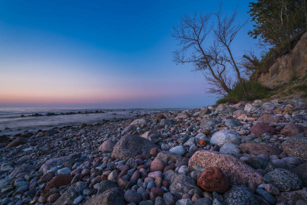 istock rocky seashore, colorful sunset on the background, long exposure 1257241726