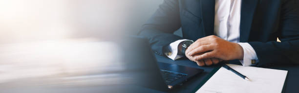 istock Businessman with documents and using laptop. Panoramic business banner with copy space. 1257243213