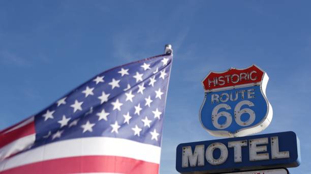 motel retro sign on historic route 66 famous travel destination, vintage symbol of road trip in usa. iconic lodging signboard in arizona desert. old-fashioned neon signage. national state flag waving - lodging imagens e fotografias de stock