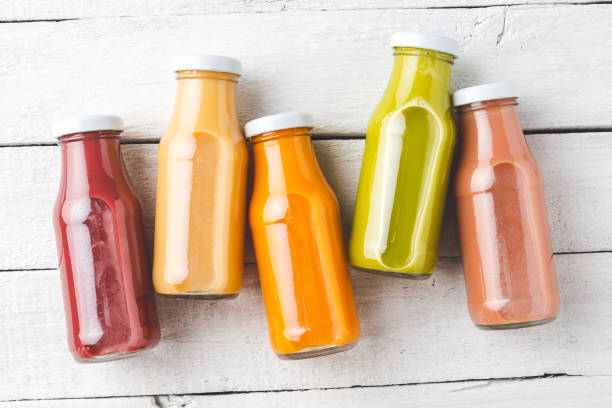 istock Colourful smoothies on white wooden table with copyspace. Fresh juices in bottles 1257243943